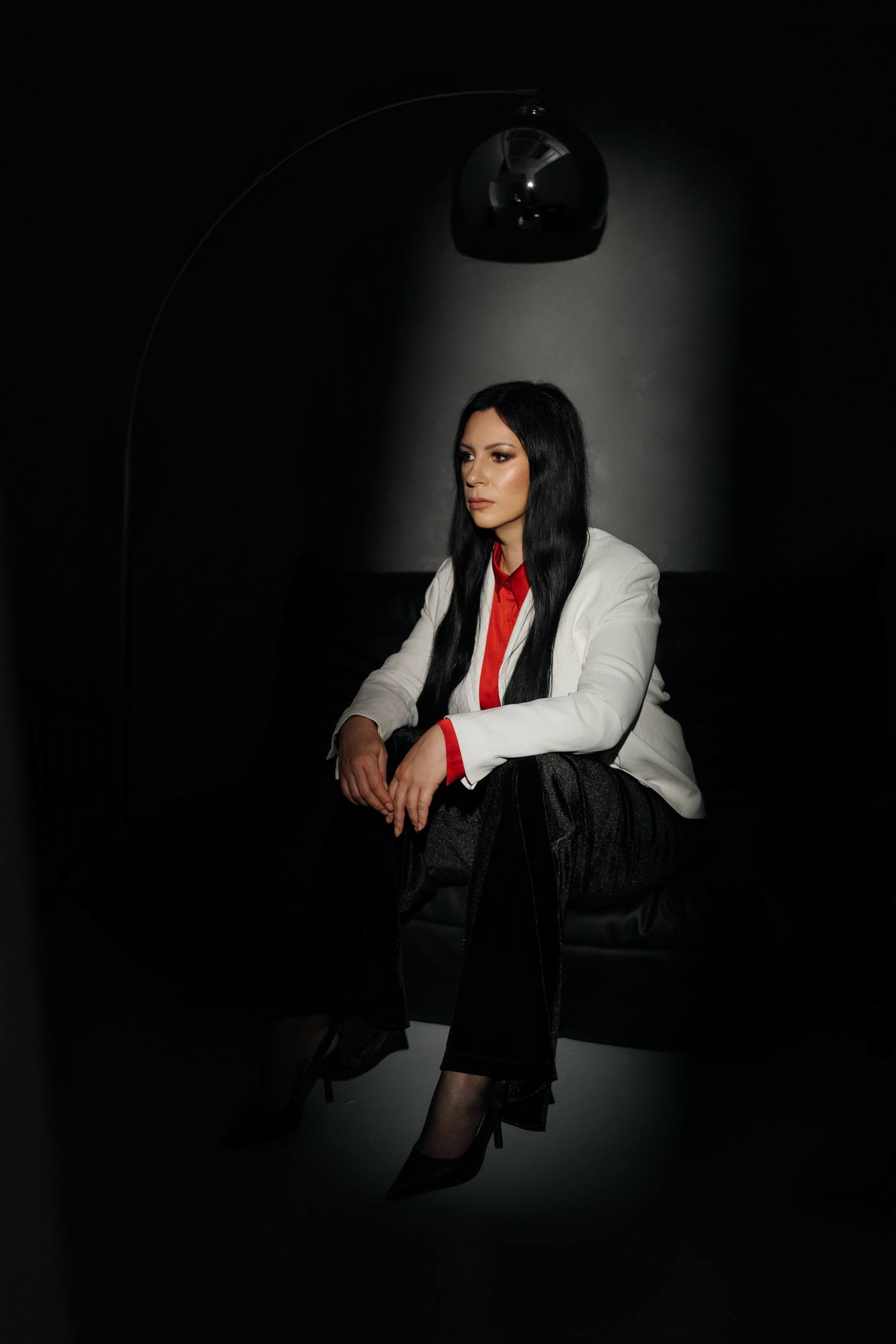 Olga, seated under an arc lamp, looking toward the text
